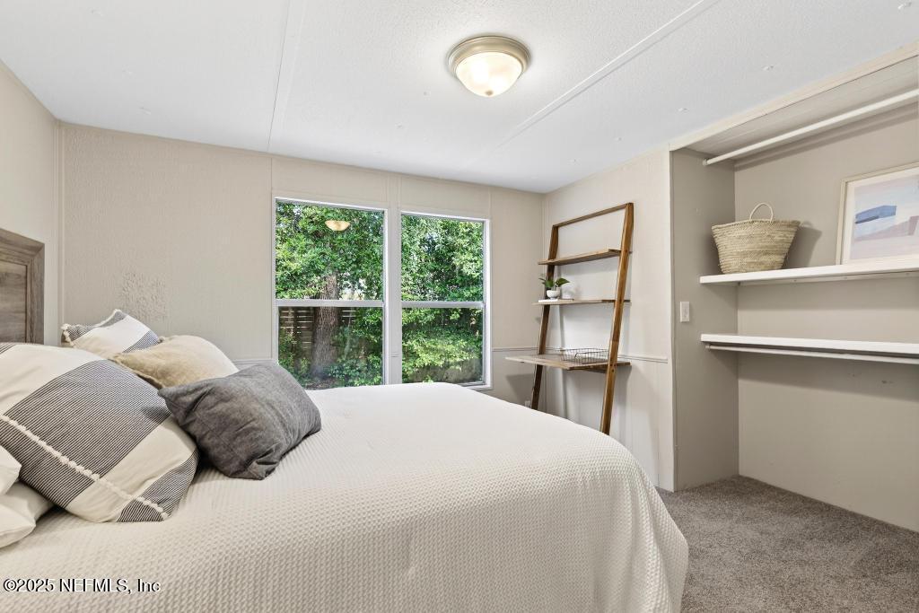 28 Neighbors Cove Road Orange Park, FL 32065 - Photo 44 of 56 a bedroom with a large bed and a large window