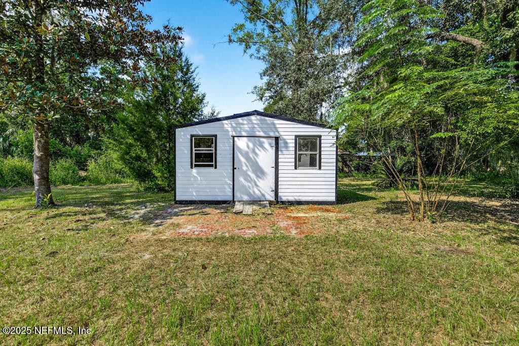 28 Neighbors Cove Road Orange Park, FL 32065 - Photo 55 of 56 a backyard of a house with plants and large tree