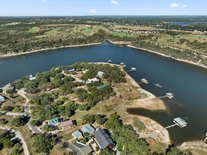 an aerial view of a residential houses with outdoor space lake and city view