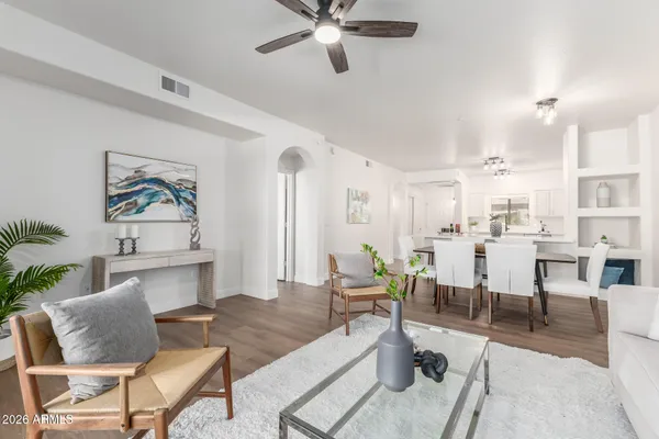 a living room with furniture kitchen view and a chandelier