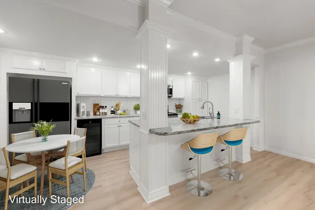 a kitchen with a dining table chairs sink and stove