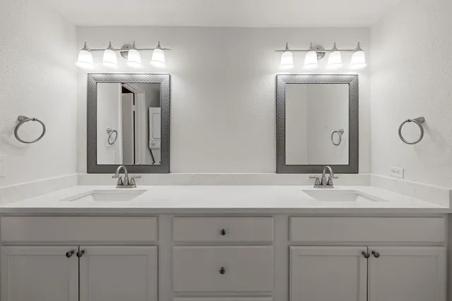a bathroom with double vanity sinks and a mirror