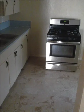 a stove top oven sitting inside of a kitchen