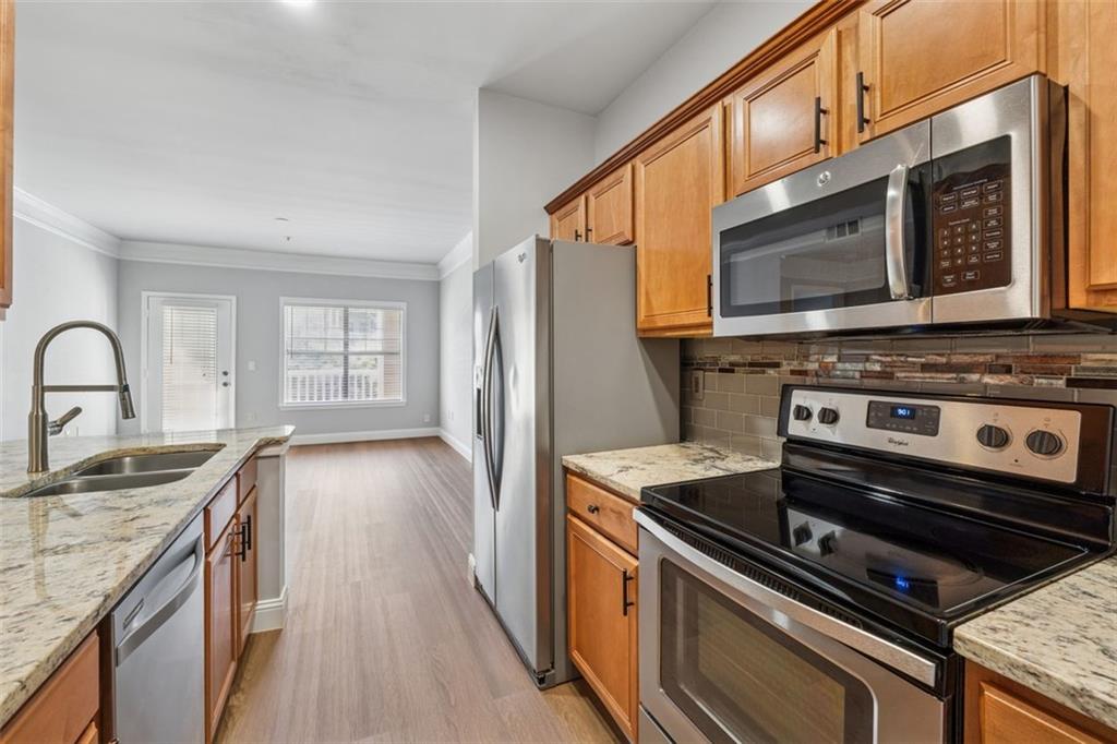 2700 Pine Tree Road Northeast, Unit 1115 Atlanta, GA 30324 - Photo 12 of 29 a kitchen with a stove a sink and a microwave