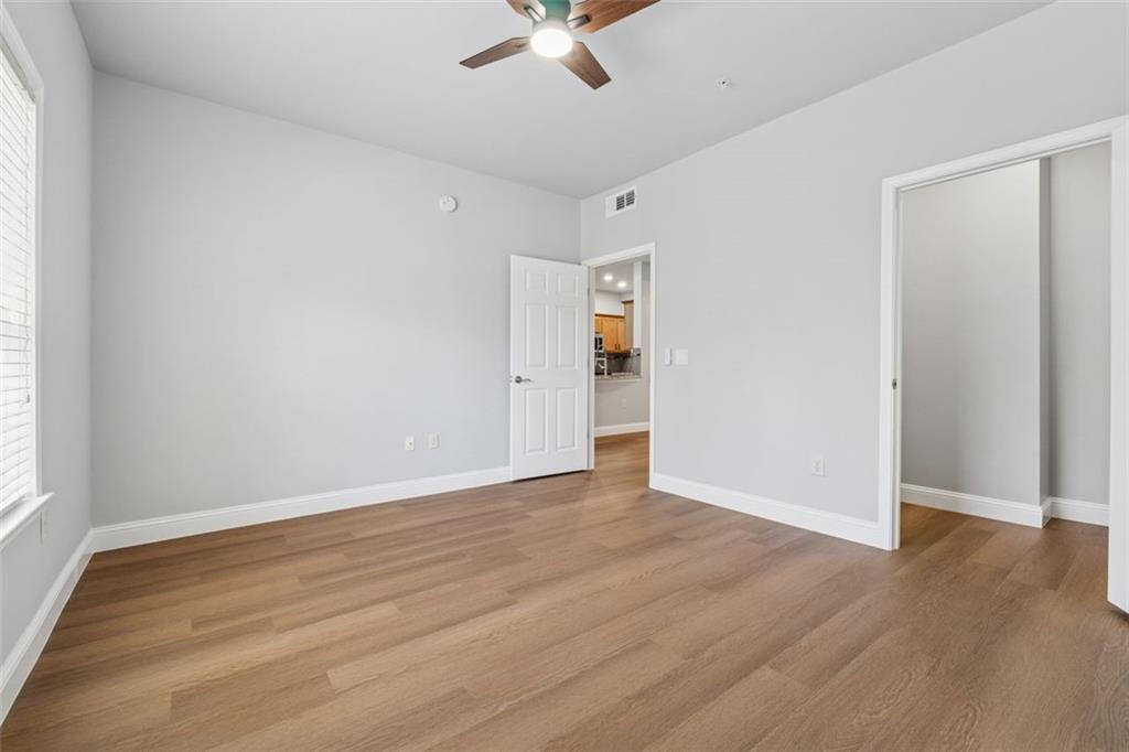 2700 Pine Tree Road Northeast, Unit 1115 Atlanta, GA 30324 - Photo 17 of 29 an empty room with wooden floor fan and windows
