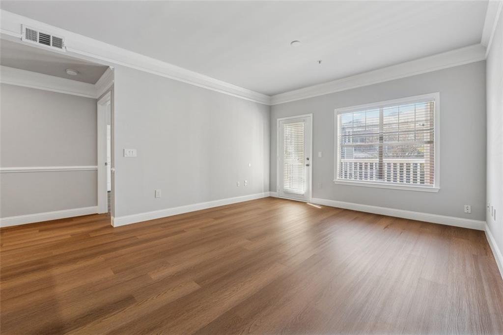 2700 Pine Tree Road Northeast, Unit 1115 Atlanta, GA 30324 - Photo 3 of 29 wooden floor in an empty room with a window