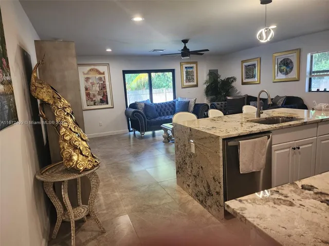 a kitchen with granite countertop a table and chairs in it