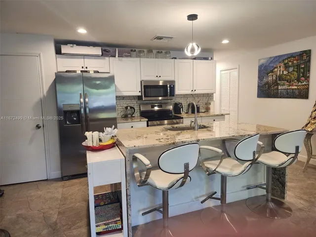 a bedroom with a bed lamp and a potted plant