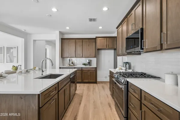 a kitchen with stainless steel appliances sink stove microwave and cabinets