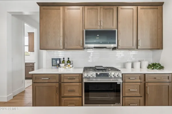 a kitchen with stainless steel appliances granite countertop a stove a sink and a microwave