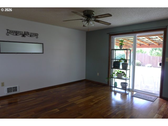 412 Camellia Court Reedsport, OR 97467 - Photo 17 of 48 a view of an empty room with a window and wooden floor