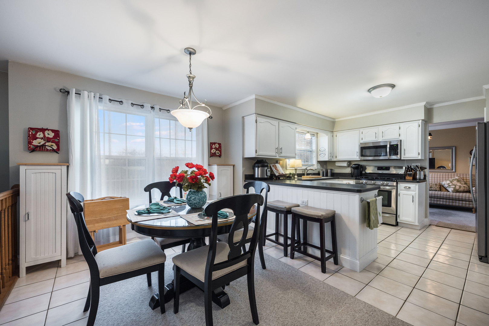 716 Pinehurst Lane Oswego, IL 60543 - Photo 11 of 25 a kitchen with a dining table chairs stainless steel appliances and cabinets