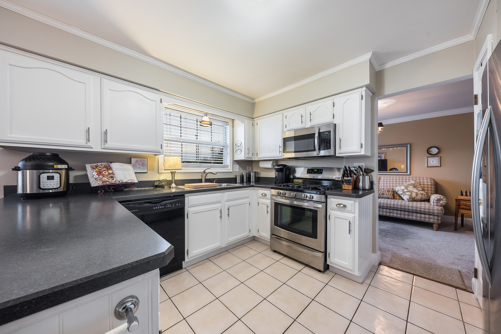 716 Pinehurst Lane Oswego, IL 60543 - Photo 7 of 25 a kitchen with stainless steel appliances granite countertop a stove top oven a sink a dining table and chairs