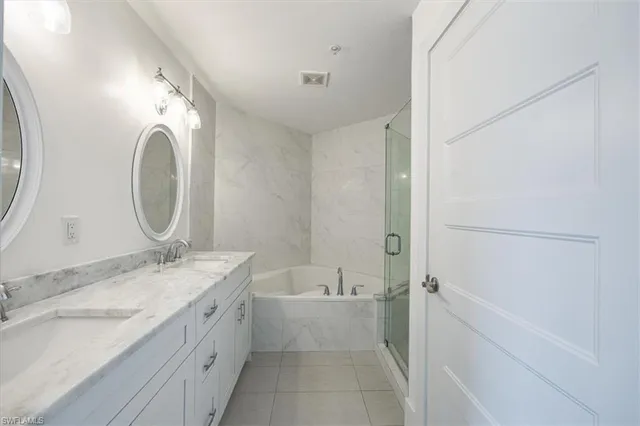 a en suite bathroom with a granite countertop sink and a mirror