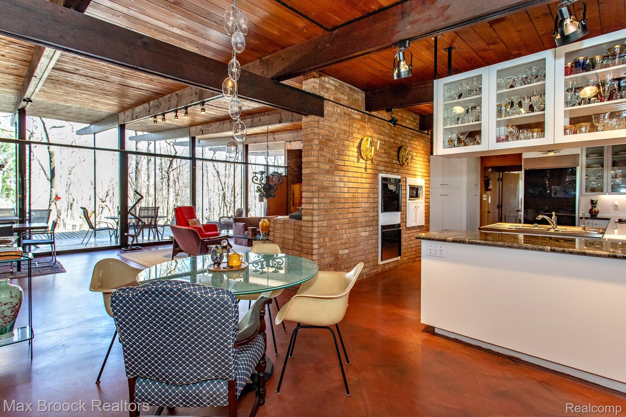 30875 Franklin Road Franklin, MI 48025 - Photo 21 of 86 Dining space with finished concrete floors, expansive windows, a wooden ceiling with exposed beams, and brick wall