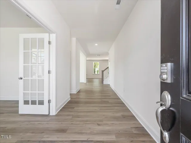an empty room with wooden floor and windows