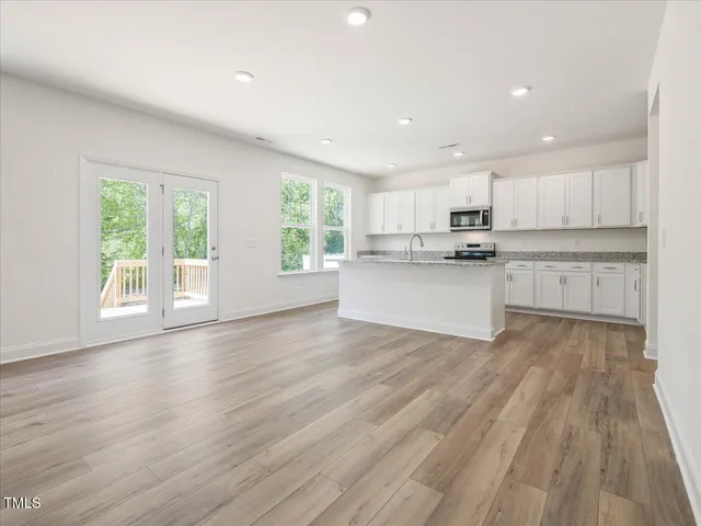 an empty room with wooden floor and window