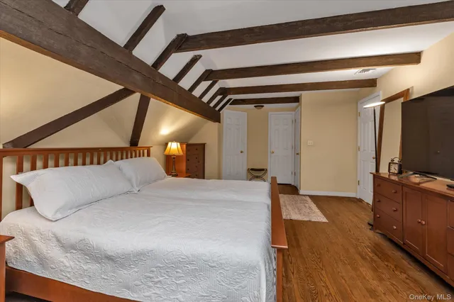 a bedroom with a large bed and a flat screen tv