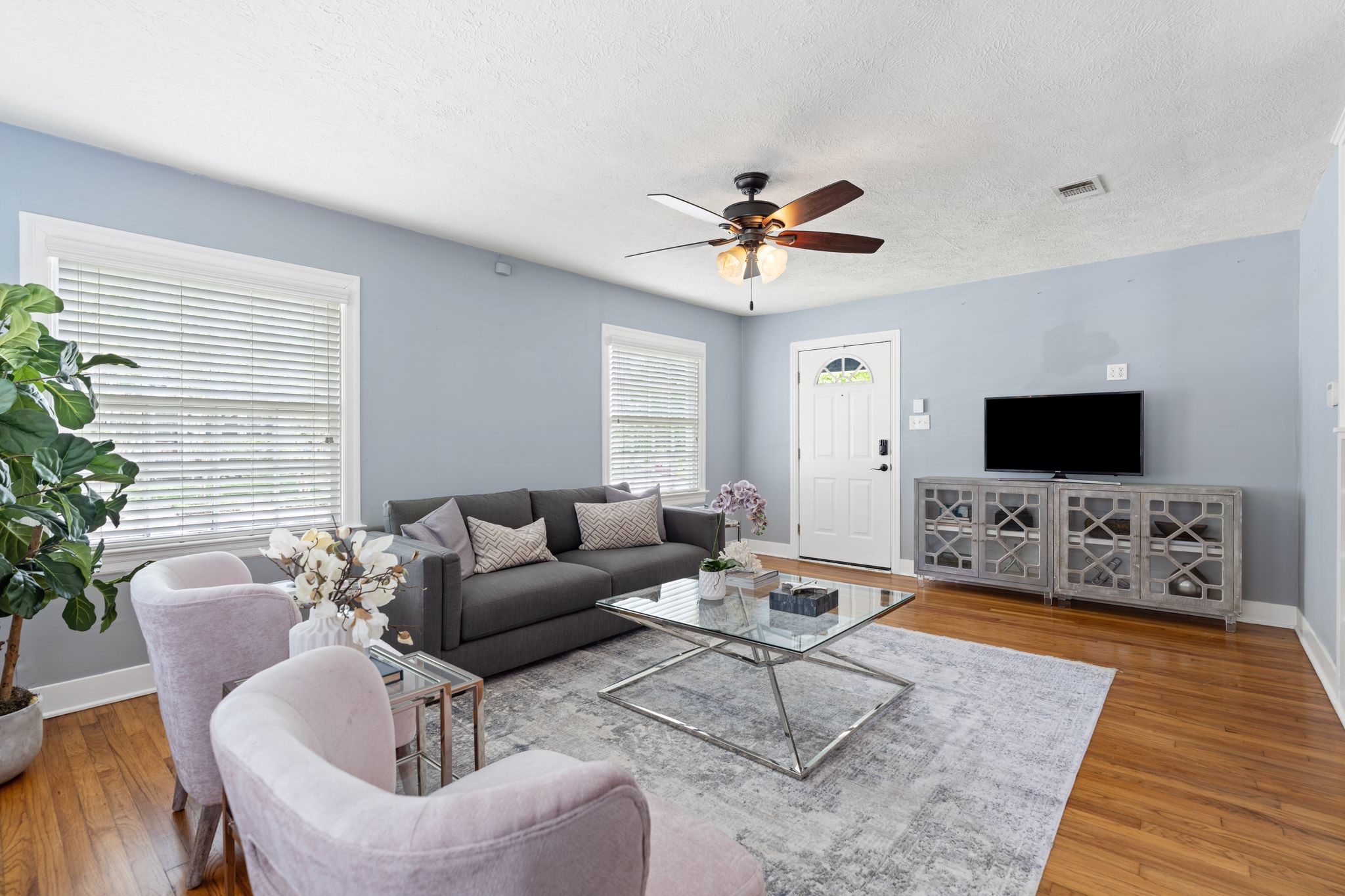 1102 Winston Street Houston, TX 77009 - Photo 2 of 30 a living room with furniture a flat screen tv and a potted plant