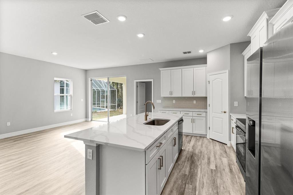 9 Fringetree Street Homosassa, FL 34446 - Photo 12 of 37 a kitchen with a center island appliances wooden floor and a window