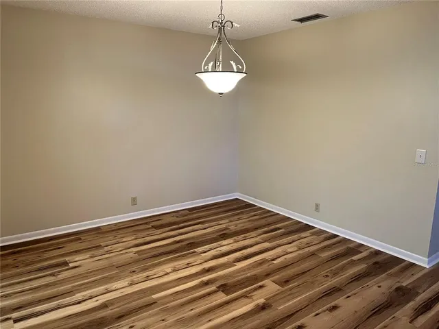 a view of a room with wooden floor and fan