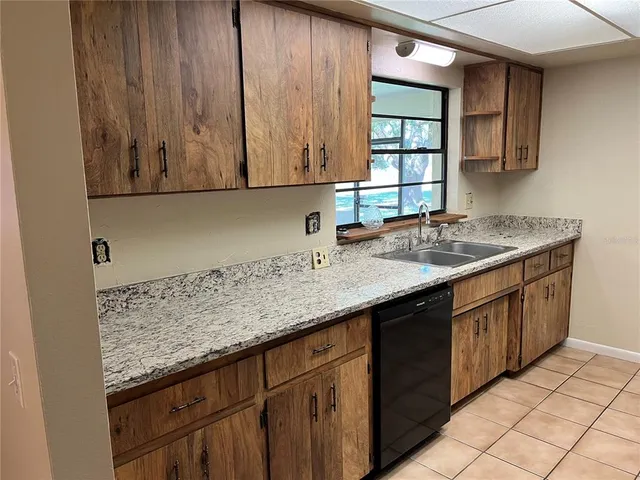 a kitchen with granite countertop a stove top oven cabinetry a sink and dishwasher