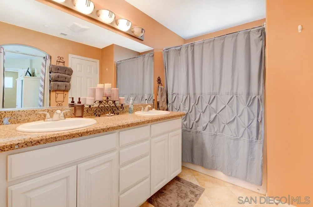 8713 Glen Oaks Way Santee, CA 92071 - Photo 11 of 22 a bathroom with a granite countertop sink and a mirror