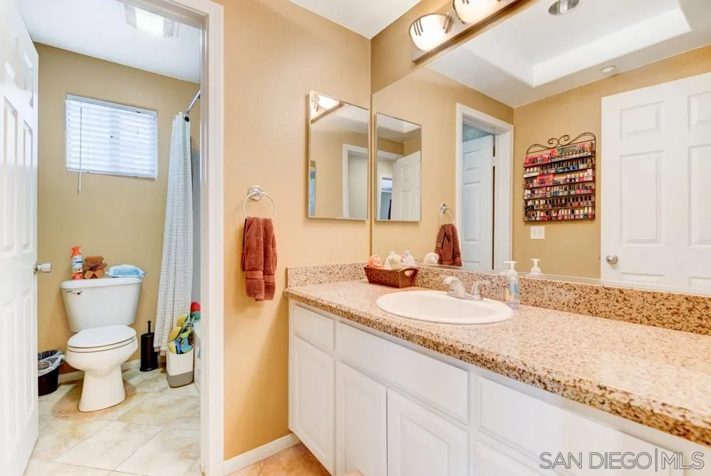 8713 Glen Oaks Way Santee, CA 92071 - Photo 15 of 22 a bathroom with a granite countertop sink and a mirror