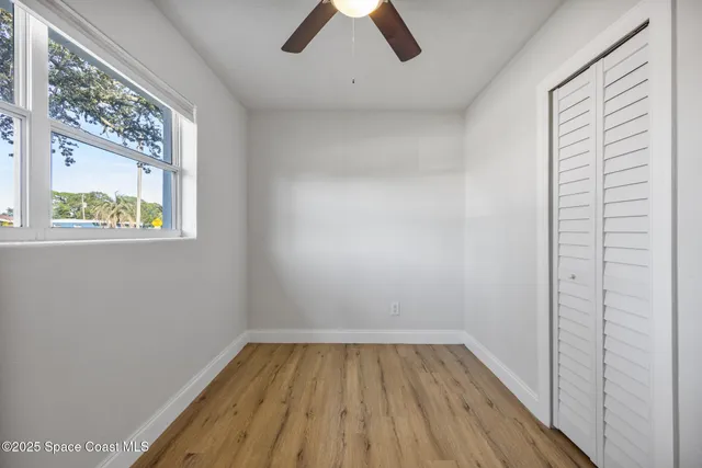 a view of empty room with window and wooden floor