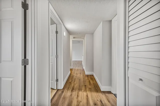 a view of a hallway with wooden floor and staircase