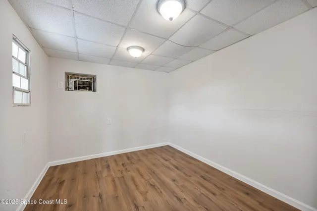 a view of empty room with wooden floor