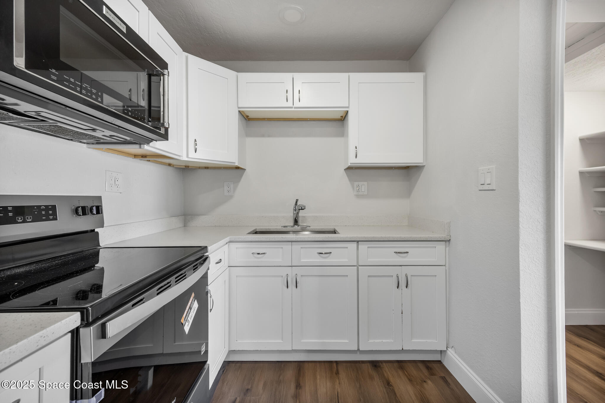 1107 Alamanda Lane Cocoa, FL 32922 - Photo 7 of 24 a kitchen with granite countertop a sink cabinets and stainless steel appliances