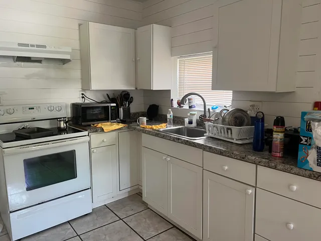 a kitchen with white cabinets and white appliances