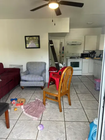 a living room with furniture a flat screen tv and kitchen view