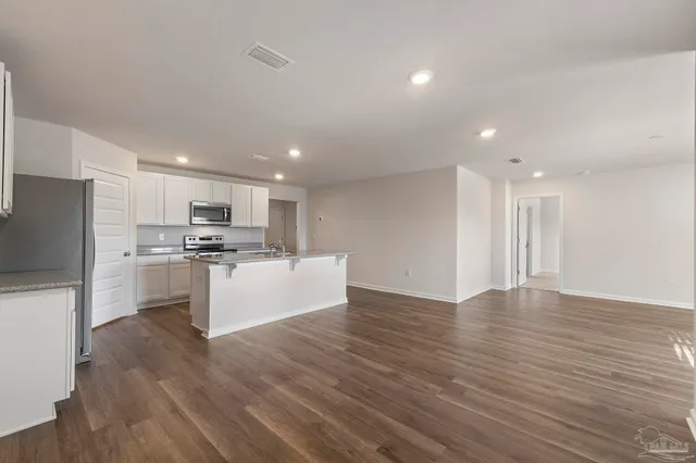 a kitchen with stainless steel appliances granite countertop a sink stove refrigerator and microwave