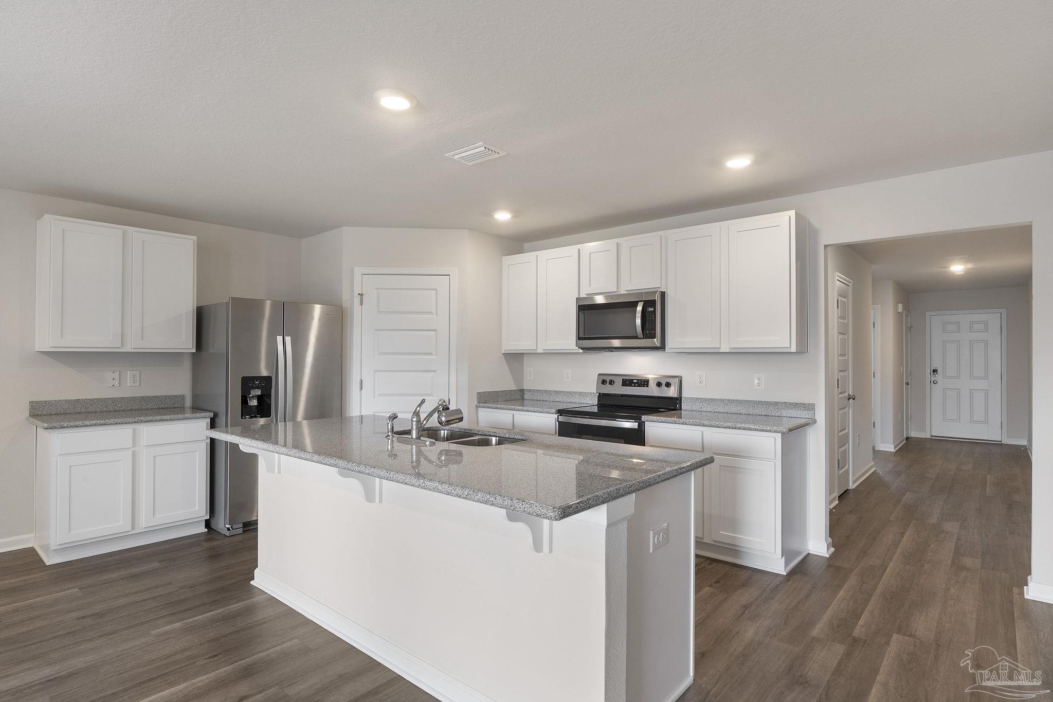 8669 Pathstone Boulevard Pensacola, FL 32526 - Photo 14 of 36 a kitchen with stainless steel appliances granite countertop a sink stove refrigerator and microwave