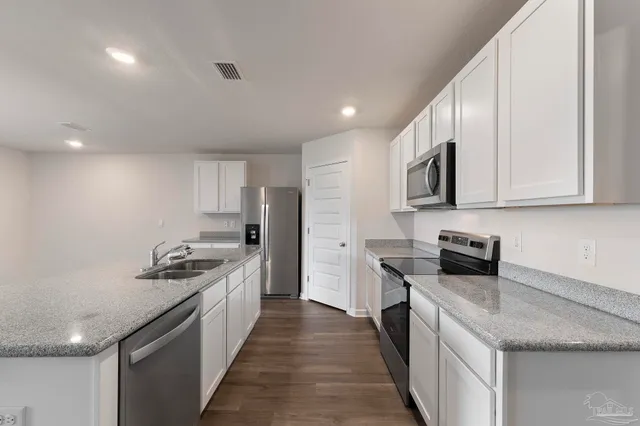 a view of a kitchen island a sink a window and wooden floor