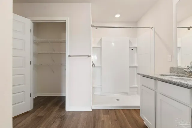 a bathroom with double vanity sinks and a shower