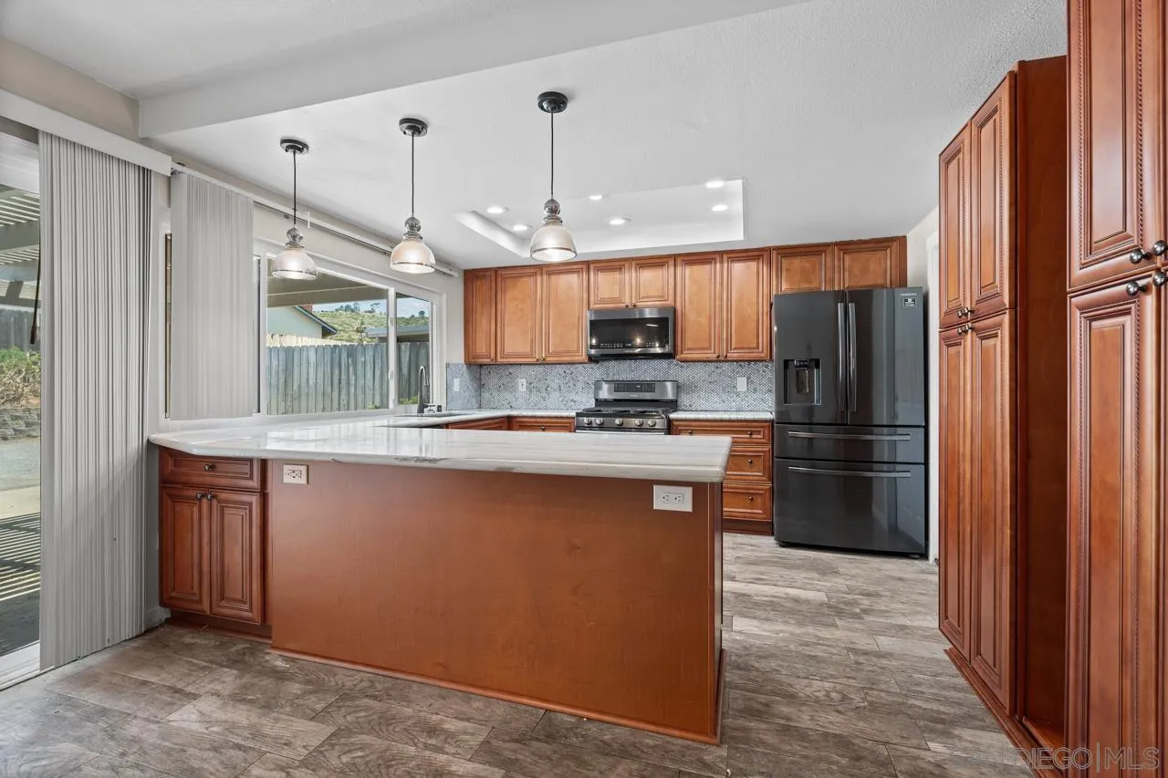 14932 Cinchring Drive Poway, CA 92064 - Photo 5 of 14 a kitchen with stainless steel appliances granite countertop a refrigerator a sink and a stove