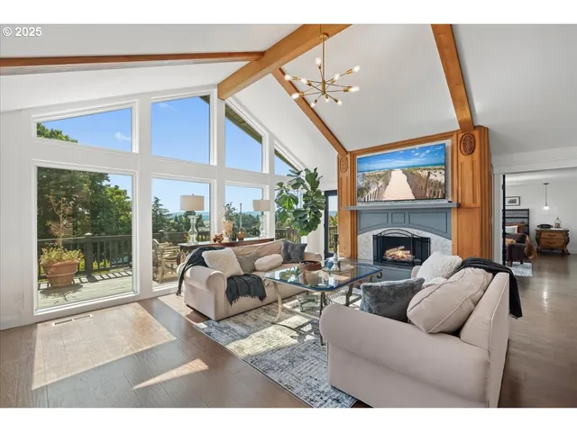 a living room with furniture a floor to ceiling window and a fireplace