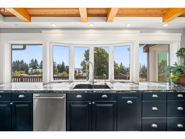 a kitchen with granite countertop a sink and a large window