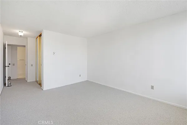 a view of a hallway with wooden floor and a bathroom