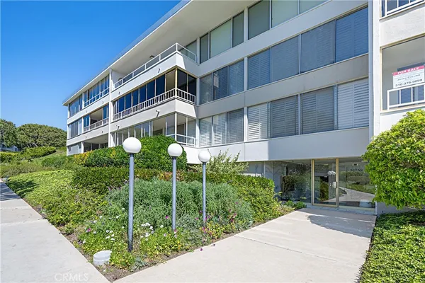a view of a hallway with wooden floor and a bathroom
