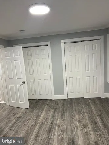 a view of empty room with wooden floor and window