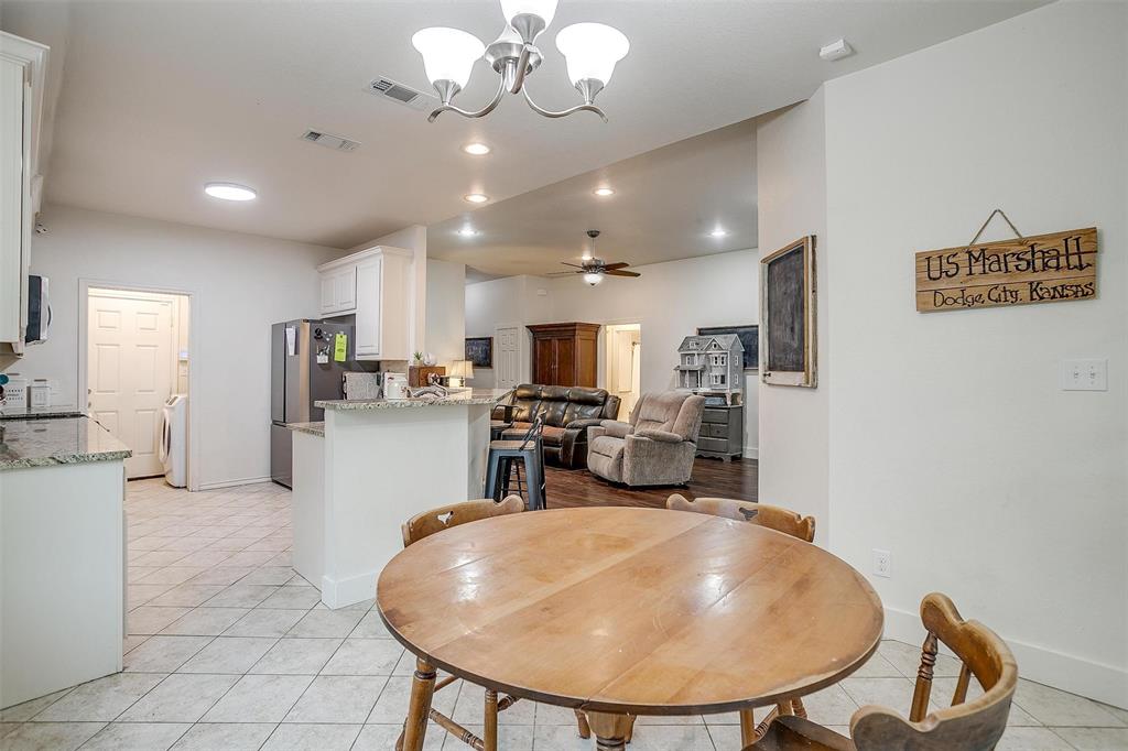 228 Lovers Path Drive Springtown, TX 76082 - Photo 14 of 40 Dining space with visible vents, baseboards, light tile patterned flooring, and ceiling fan with notable chandelier