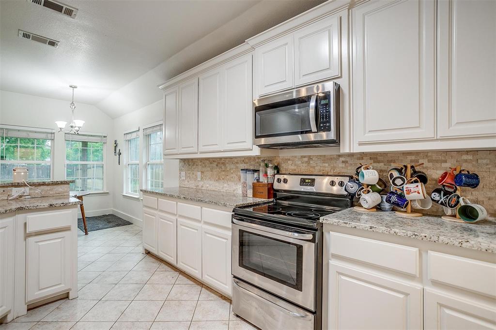 228 Lovers Path Drive Springtown, TX 76082 - Photo 19 of 40 Kitchen with vaulted ceiling, backsplash, visible vents, and appliances with stainless steel finishes
