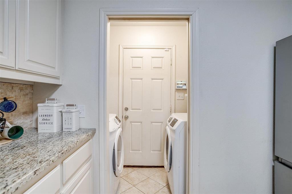 228 Lovers Path Drive Springtown, TX 76082 - Photo 21 of 40 Laundry area featuring light tile patterned floors, washing machine and clothes dryer, and cabinet space