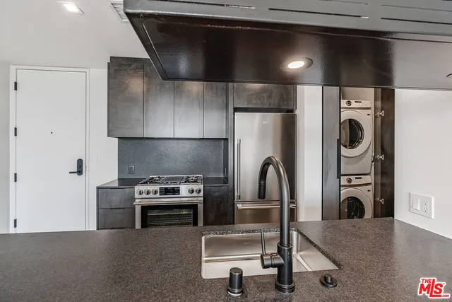 a kitchen with a refrigerator and a stove top oven