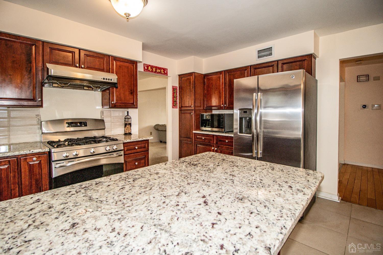 29 Devon Drive Piscataway, NJ 08854 - Photo 11 of 23 a kitchen with stainless steel appliances kitchen island granite countertop a refrigerator and a stove top oven