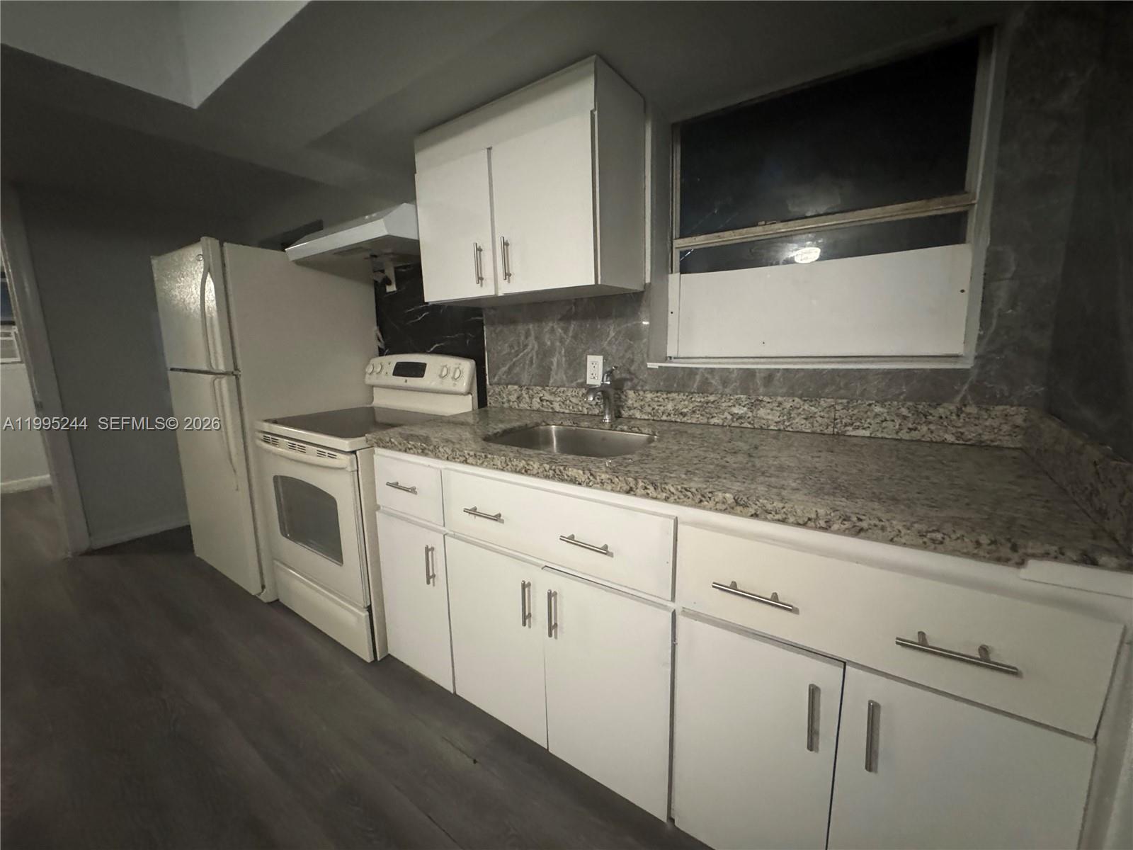 a kitchen with stainless steel appliances granite countertop a sink a stove and a refrigerator